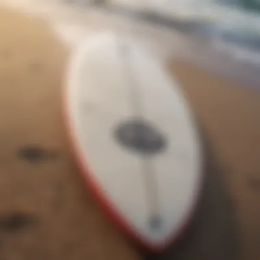 A close-up view of a surfboard along the sandy beach.