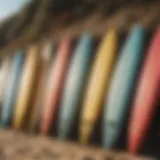 A variety of surfboards lined up on the beach, showcasing different shapes and sizes.