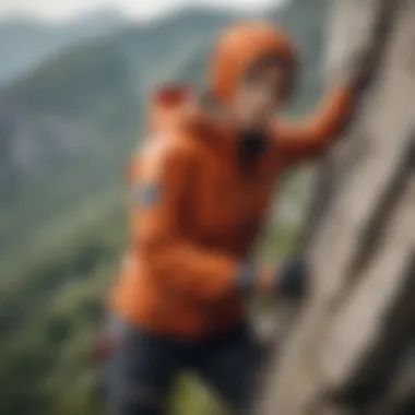 An athlete wearing a windbreaker hoodie while engaged in rock climbing against a scenic backdrop.